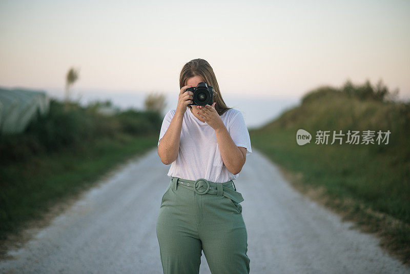 一个带着单反相机的年轻女人