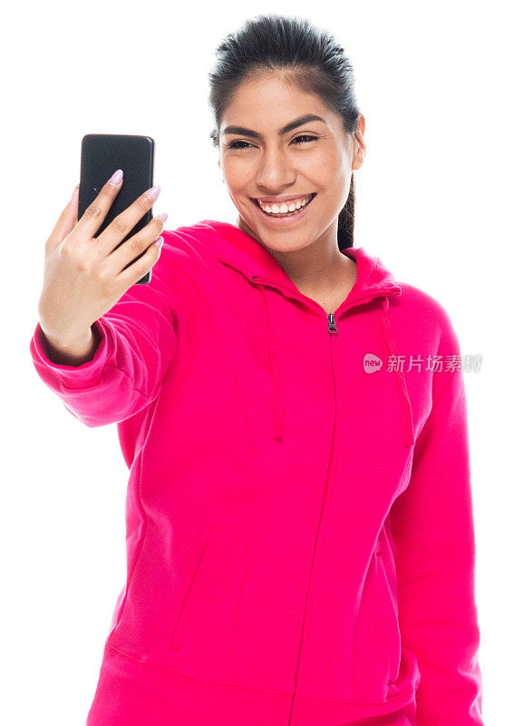 z一代女性穿着运动衫站在白色背景前用手机拍照