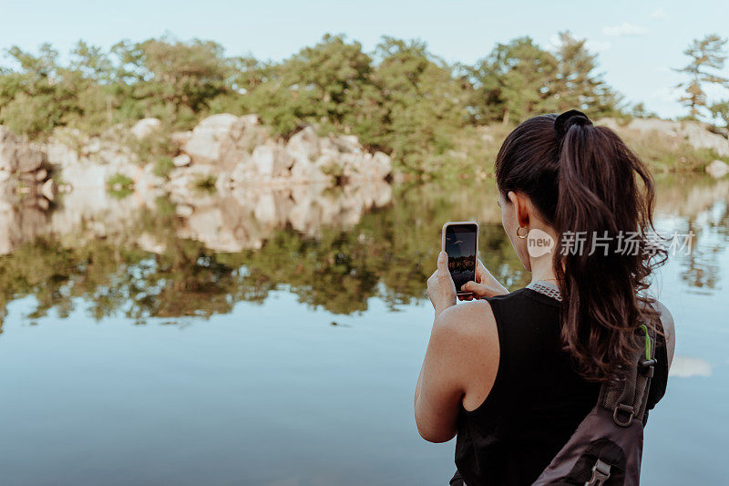 女子在小径上徒步旅行并拍照