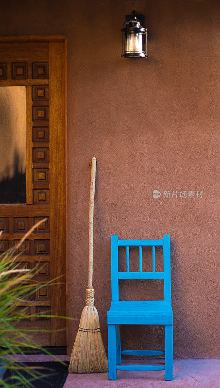 扫帚和乡村蓝色椅子靠近木门
