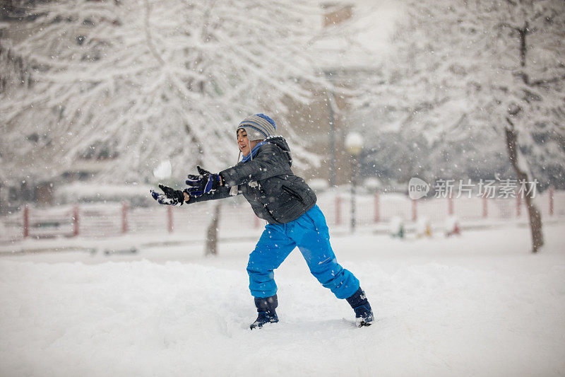 可爱的男孩在雪中玩耍