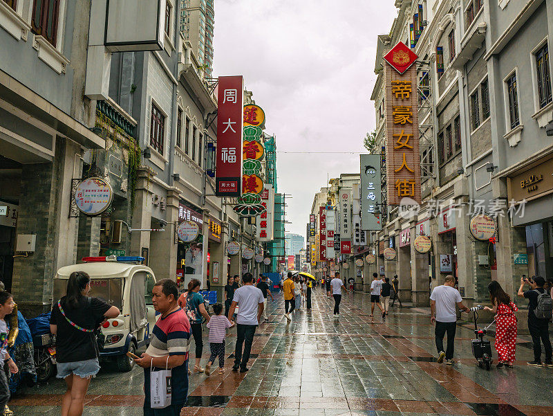 下着雨，陌生的人们走在广州上下九步行街。上下九步行街，简称上下九，是一条商业步行街