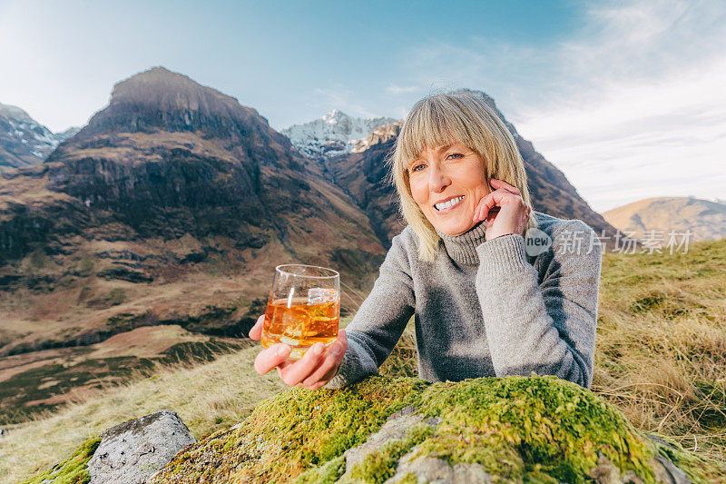 在苏格兰的格伦科，拿着一杯威士忌的女人