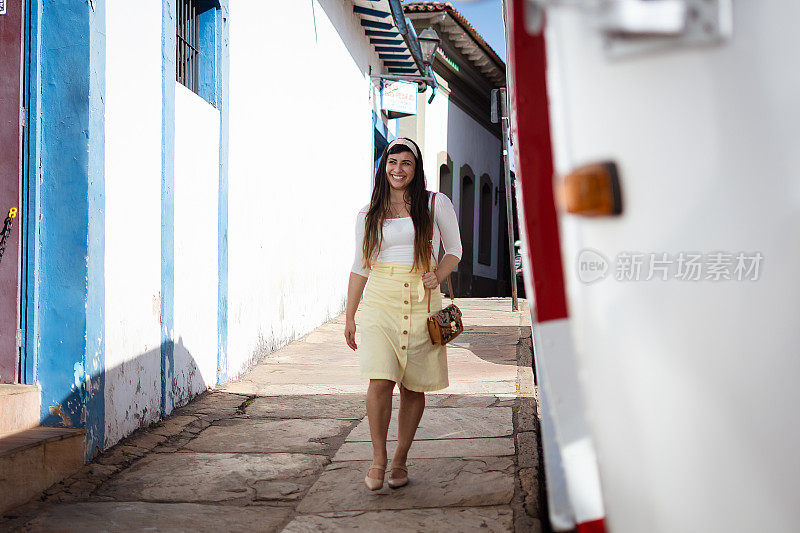 年轻的女游客兴奋地走过这座历史名城的街道。