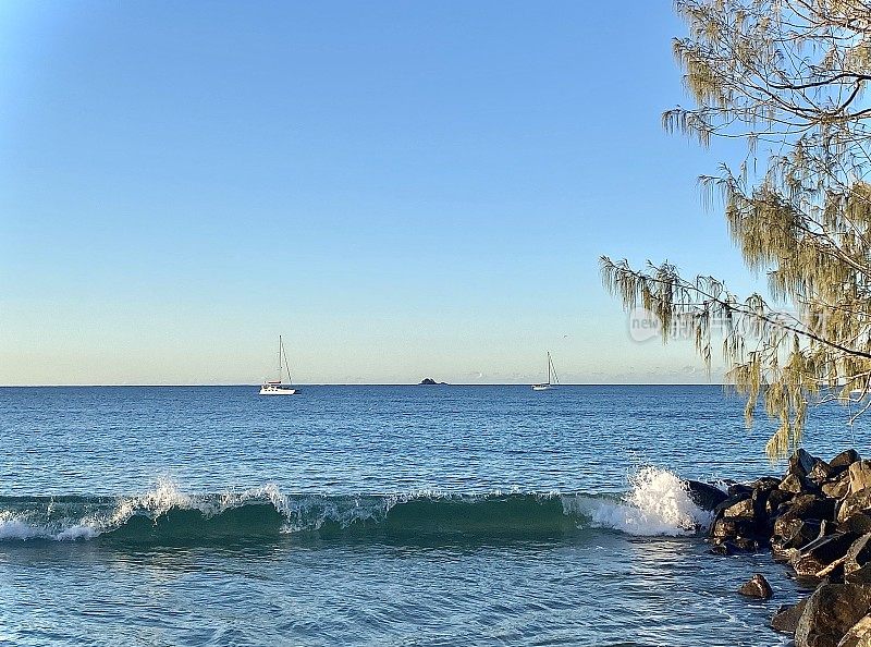 在海滩海岸线的岩石上破浪