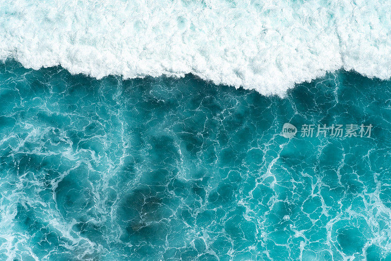 纹理浅蓝的表面汹涌的海水与白色泡沫和波浪图案