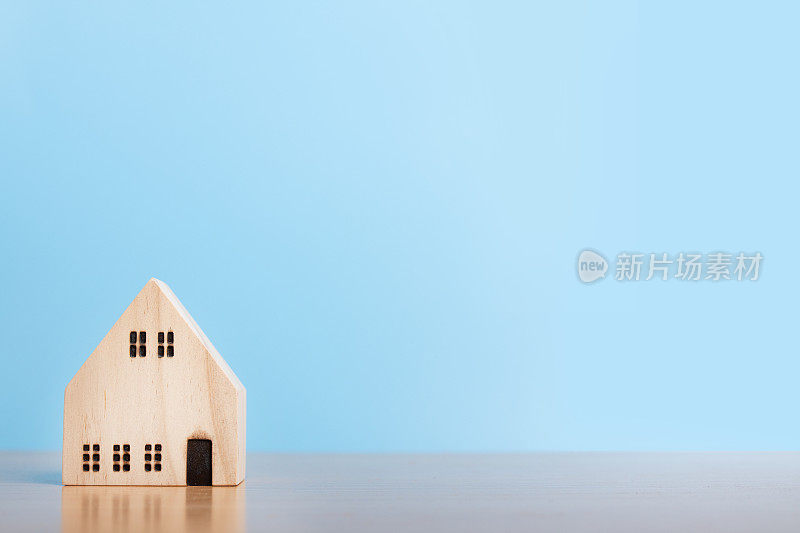 蓝色背景上的房子模型。家庭住宅，保险和房地产投资概念。副本的空间。
