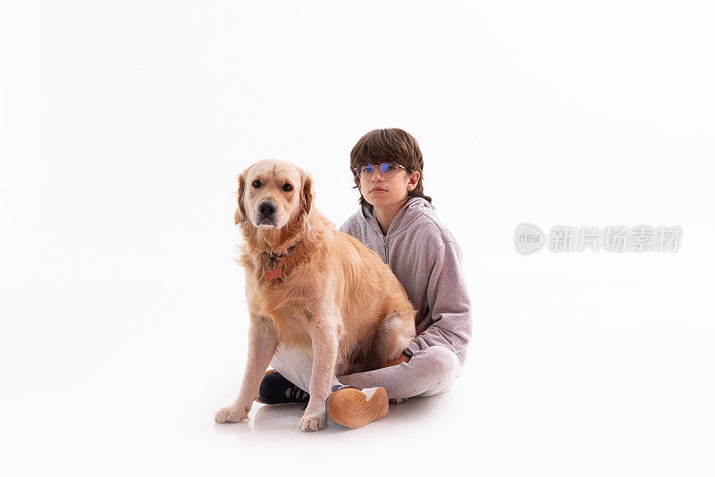 一个小男孩和一只金毛猎犬在一起。