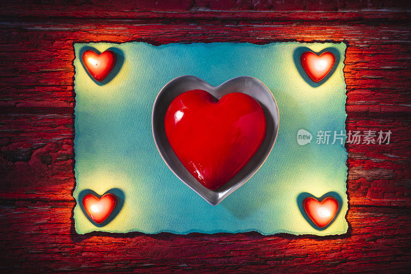 情人节的红心蛋糕，在心形的盘子和发光的心型蜡烛