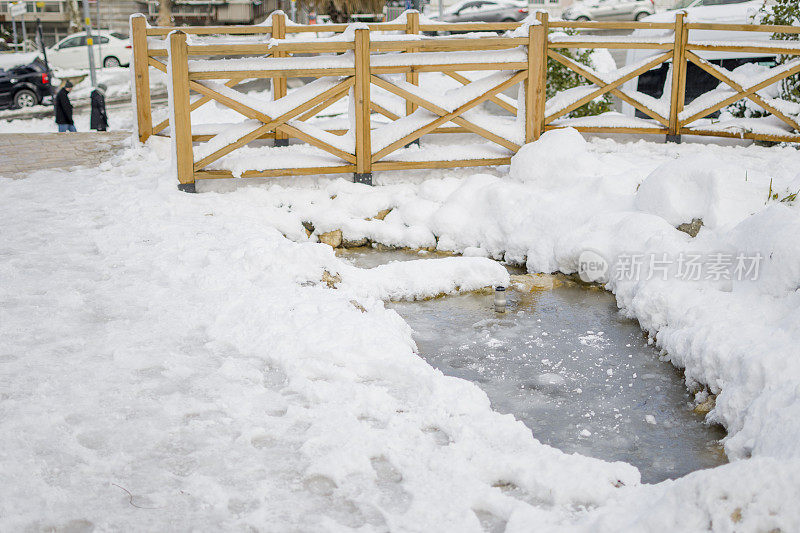 美丽的冬季公园，结冰的水覆盖着雪