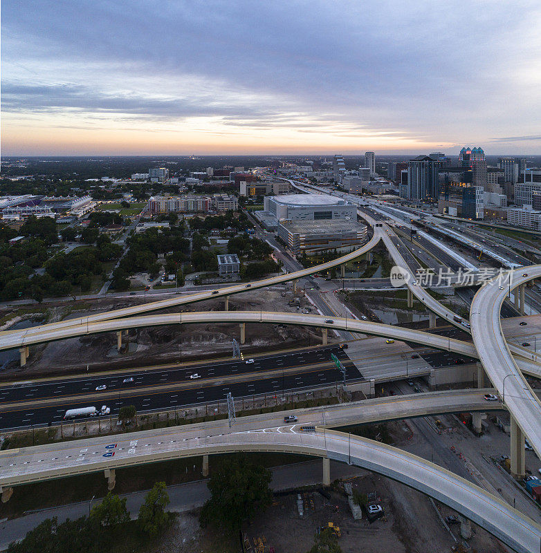宽广的空中全景，奥兰多市中心的巨大交通枢纽与高速公路，多个天桥在清晨日出。超大，高分辨率的拼接全景图。