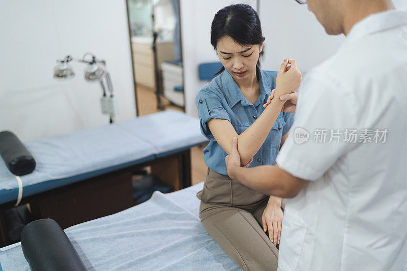 中医疗法——一名中医正在检查一名女性病人的疼痛和溃疡
