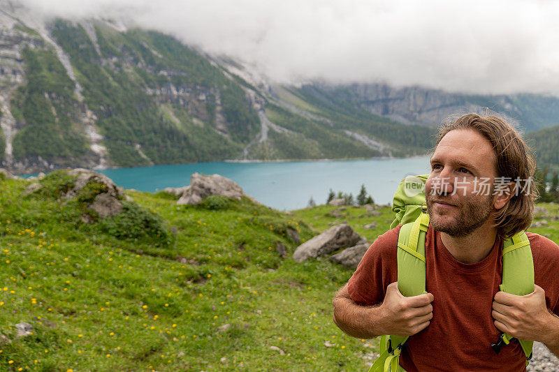 年轻人在美丽的高山风景中徒步旅行，夏天在瑞士的阿尔卑斯山漫步，享受大自然和户外活动