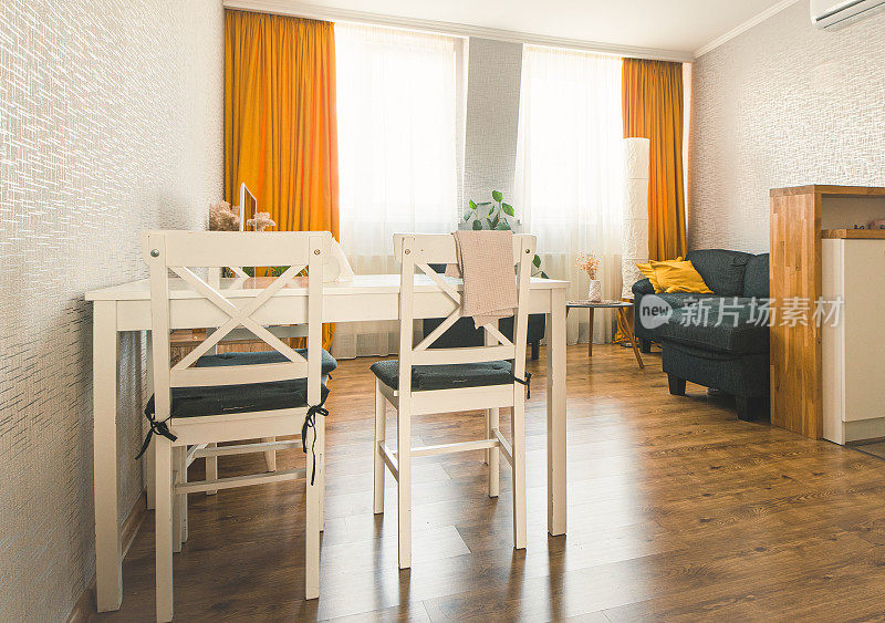 舒适的工作室公寓厨房，桌子沙发和明亮的室内秋季调色板