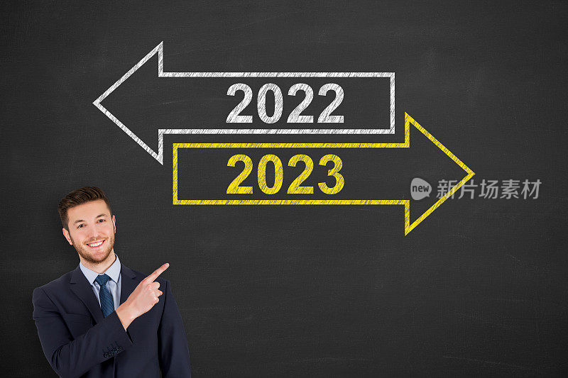 商人在黑板背景上画旧年或2023年