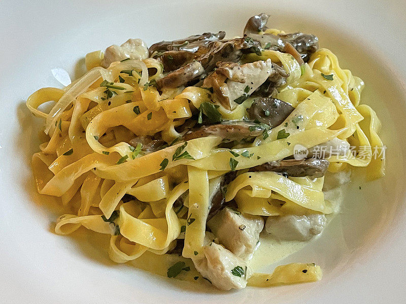 全帧图像的奶油鸡和蘑菇意大利面条食谱在意大利餐厅，吃出意大利面菜在白色盘子，高架的观点