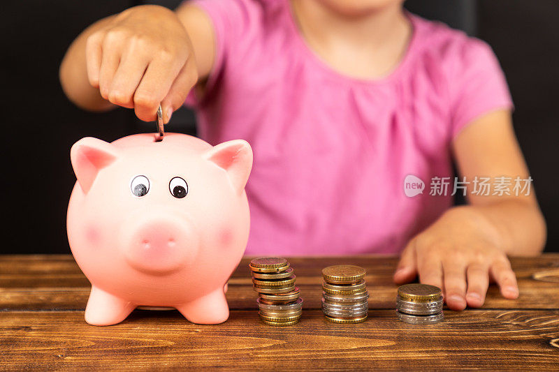 一个背景上有一个孩子的小猪存钱罐的特写镜头