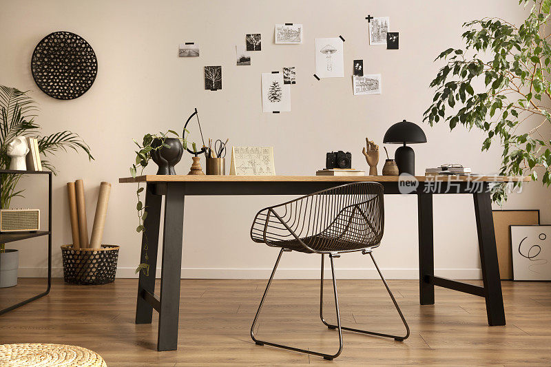 金属椅，木桌，植物海报和个人配件组成了舒适的办公室内部。家居装饰。模板。
