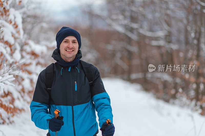 一个年轻英俊的男子徒步旅行者在山顶的腰肖像