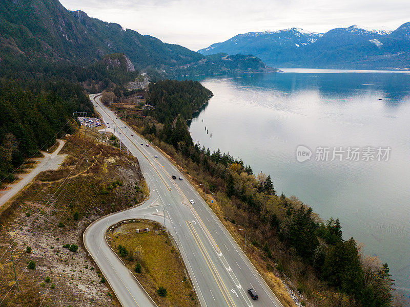 高速公路和火车轨道在山腰沿着海洋入口运行，汽车驾驶Arial照片