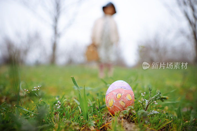 小女孩手里拿着五颜六色的复活节彩蛋。孩子们在春天公园里收集彩绘彩蛋。孩子们在户外寻找鸡蛋。