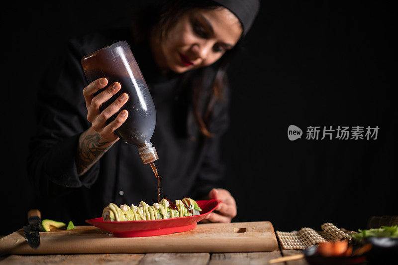 女寿司师傅正在准备一盘寿司