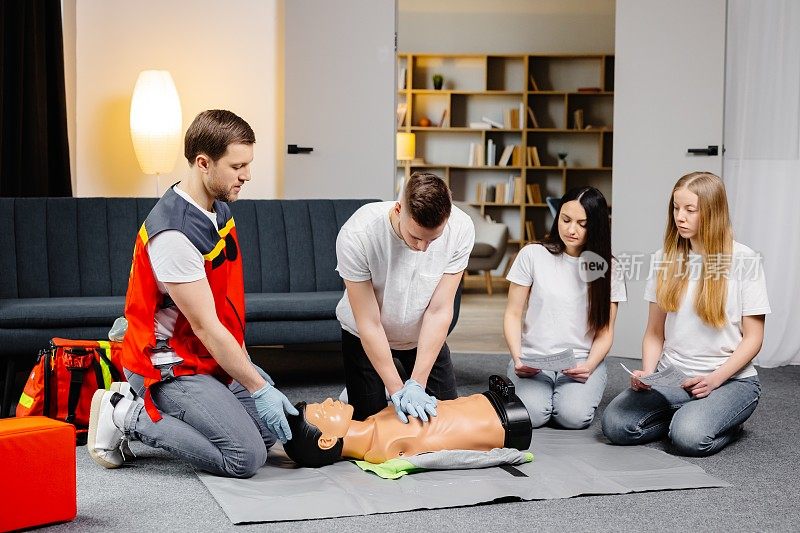 青年教官在室内集体训练时帮助用假人做急救心脏按压