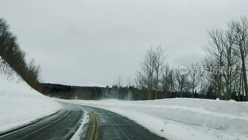 司机POV下雪的冬季山路与高雪堤在科罗拉多州西部照片系列