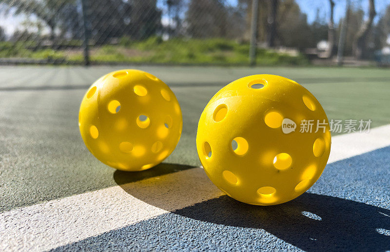 小黄色匹克球，大背景匹克球:匹克球场边界线上的黄色匹克球