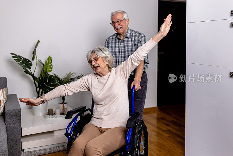 坐在轮椅上的妻子在家里被爱她的丈夫扶着