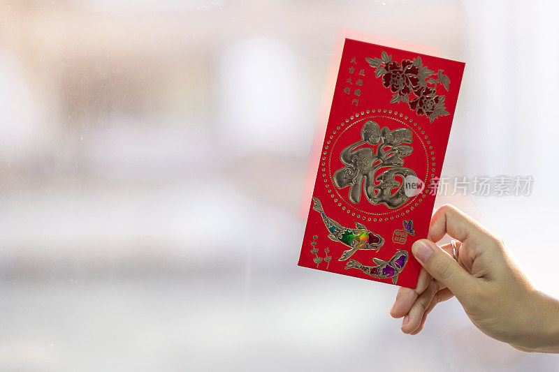 手握红包或红包。中国农历新年庆祝概念，中文意思是幸运和成功