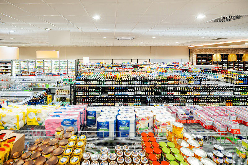 超市货架上摆满了各种罐装和瓶装农产品