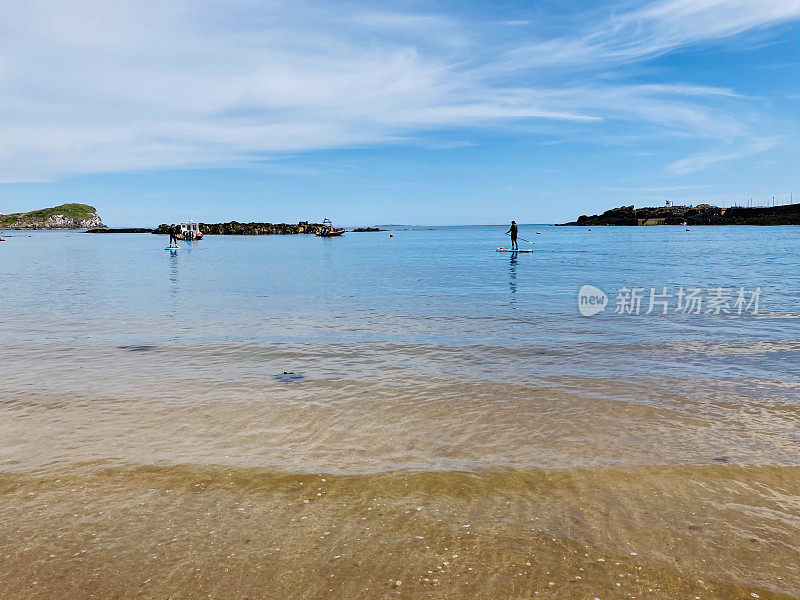 在清澈碧绿的海水和白色沙滩上冲浪，湛蓝的天空