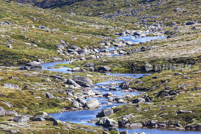 一条淡水河流经澳大利亚新南威尔士州雪山中的绿色岩石山谷