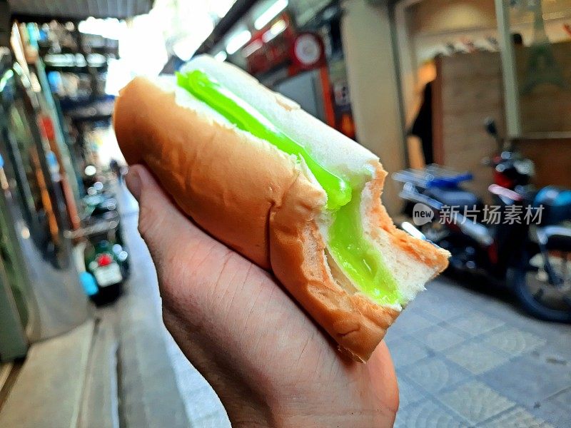 手握咬甜熊猫面包包-曼谷街头小吃。
