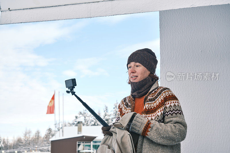 快乐的女游客在冬季山区度假胜地拍摄视频