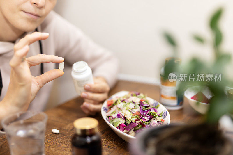 女人在用笔记本电脑吃药