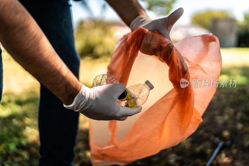 一个回收者在公园里收集垃圾的特写