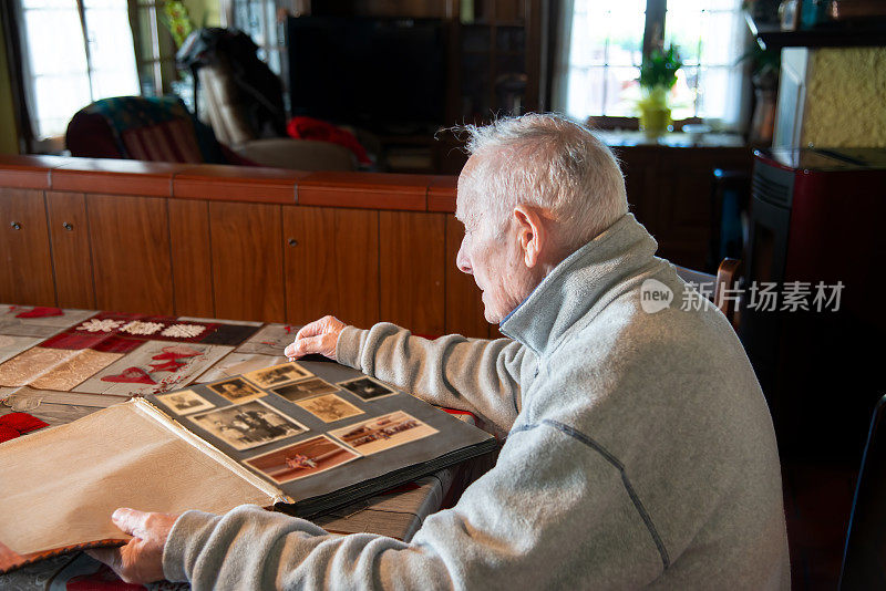 记忆。退休。一位老人在家庭相册上翻看照片