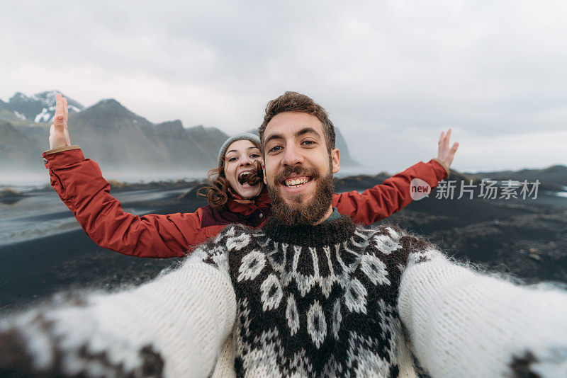 一男一女在海边的韦斯特拉霍恩山附近自拍