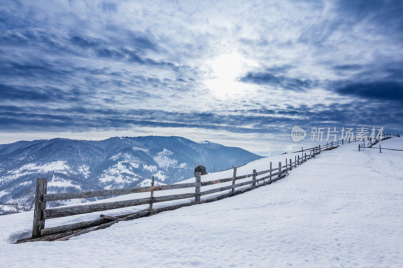 山峰上的雪被风吹走了。冬天的风景。天很冷，下着雪。