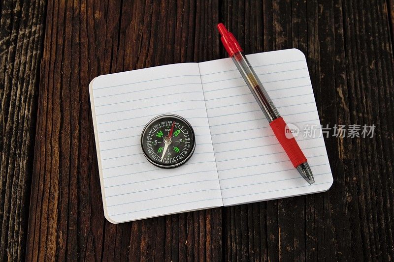指南针在小笔记本上用红墨水笔