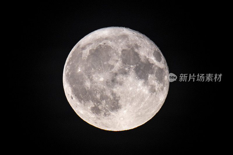 日落后夜空中的满月，月球表面有清晰可见的结构