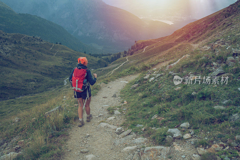 年轻女子徒步行走在山路上