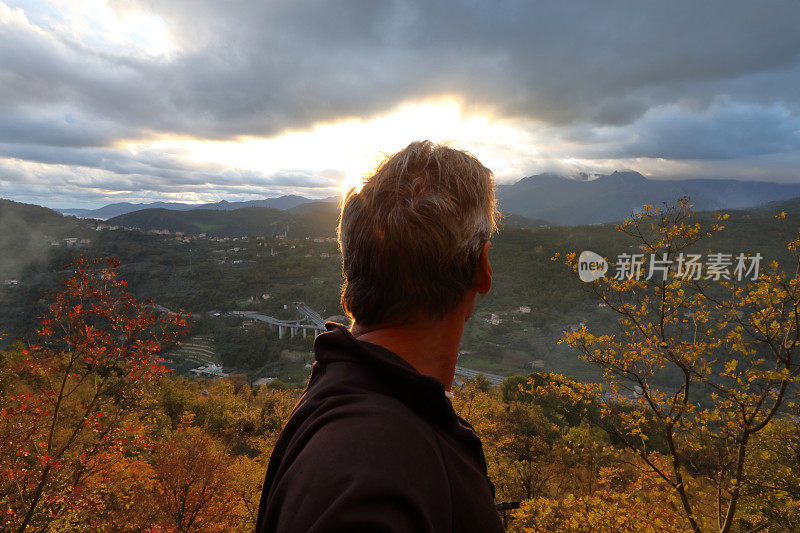 日落时分，人们眺望着秋天的森林和山谷