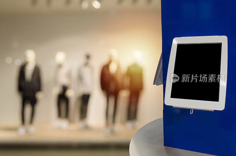 黑屏数码显示器或平板电脑柜台上模糊形象的流行男士时尚服装商店橱窗，在商场或百货公司的商业、营销和广告概念