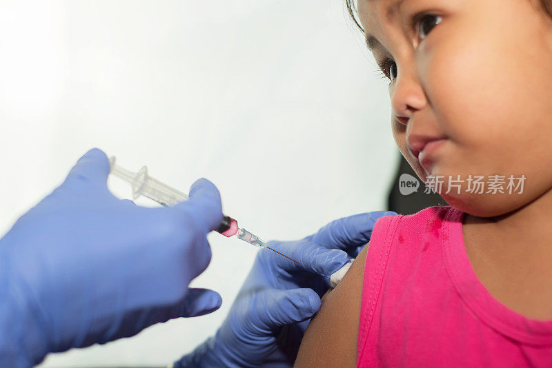 接种疫苗。医生为幼稚园注射流感疫苗。孩子的脸显示害怕注射。