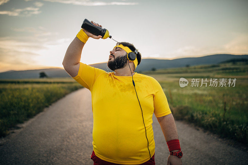 一个超重的男人往他脸上泼水