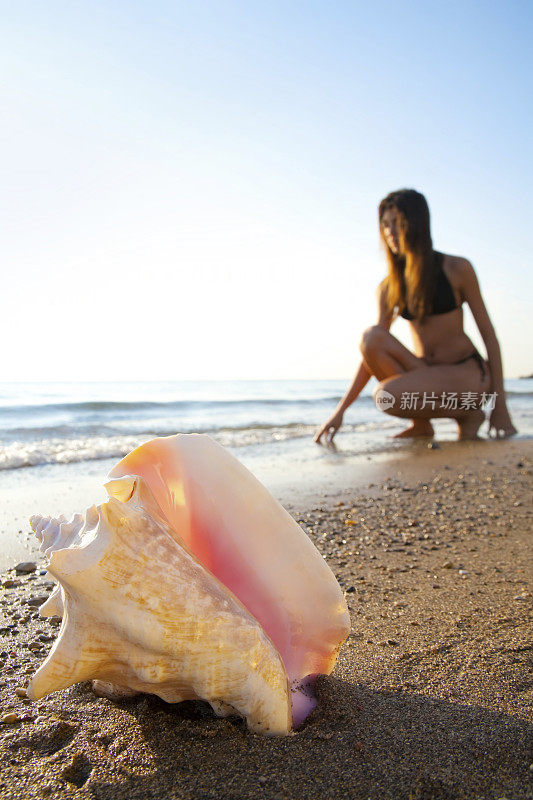 海螺壳和沙滩上的女人