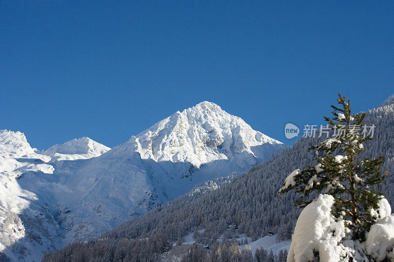 冬天的山峰被雪覆盖，蓝天